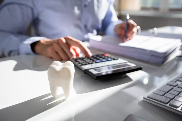 Close-up Of Tooth In Front Of a person Calculating Bills