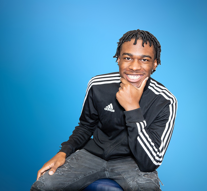 Smiling Teen Boy Holding His Chin In Hand